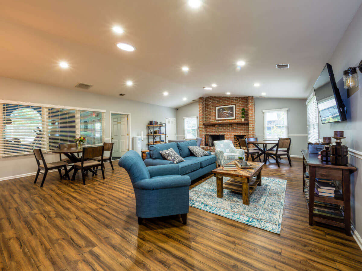 Interior view of the Pointe North apartment clubhouse with comfortable seating and TV during the day in Bethlehem, PA